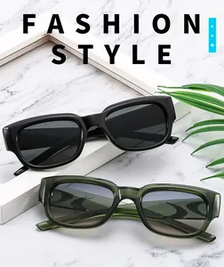 Vue détaillée de lunettes de soleil carrées en noir et vert olive sur surface en marbre