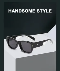Detail of vintage square black sunglasses with gold rivet accents on white geometric stand