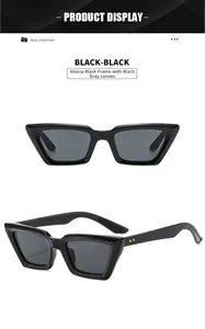 Detail view of cat-eye sunglasses with bright black frame and golden metal rivets