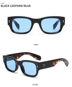 Detail of black sunglasses with blue lenses, tortoiseshell temples and metal rivets