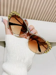 Détail de lunettes de soleil œil de chat avec verres dégradés bruns et cadre en strass