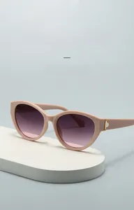 Details einer rosa Cat-Eye-Sonnenbrille mit lila Verlaufsgläsern und goldenen Metallscharnieren