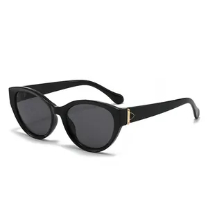 Chicke schwarze Cateye-Sonnenbrille mit goldenen Metallakzenten am Polierrahmen