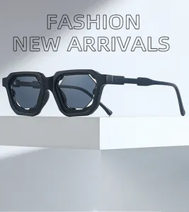 Detalle de gafas de sol geométricas negro mate en soporte minimalista con sombras