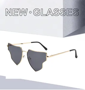 Detail of gold metal frame sunglasses with unique heart shaped grey lenses and black tips