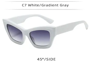 Side view of white cat eye sunglasses featuring wide temples and gradient gray lenses