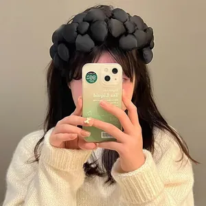 Puffy black fabric 3D flower headband worn by model in a stylish mirror selfie