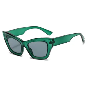 Modern cat-eye sunglasses with transparent dark green frames and gray lenses on white background