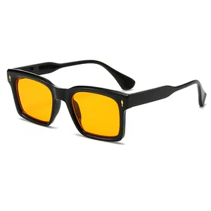 Lunettes de soleil carrées noires avec verres orange et détails fléchés dorés chic