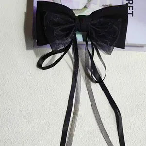 Dettaglio elegante fiocco nero in organza ricamata con nappe fluenti per capelli