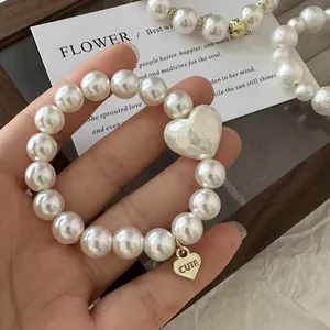 Eleganter Perlen-Haargummi mit großem Herzanhänger und goldenem Cute-Charm für Damen