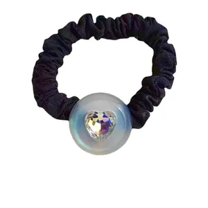 Elegant black pleated scrunchie featuring a central iridescent button and heart-shaped crystal