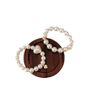 Elegantes Perlenarmband-Set mit goldenem Herzanhänger und graviertem CUTE-Schriftzug Detail