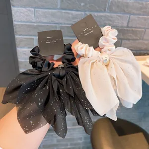 Sparkling starbow hair scrunchie in black and cream chiffon with metallic charm detail