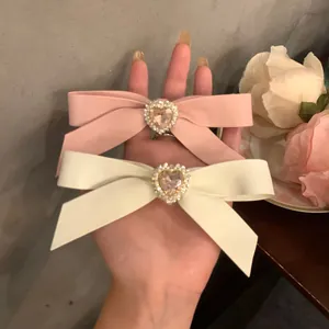 Rosa und creme Schleifen-Haarspangen mit Herz-Strass und Perlen im 2er-Set