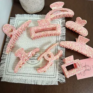 Pink and yellow acetate marble hair claws set with various geometric shapes and textures