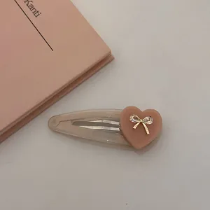 Barrette à cheveux cœur rose avec nœud doré et strass sur base champagne