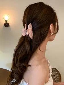 Pink marble texture acetate butterfly hair claw clip shown on a soft half-up hairstyle
