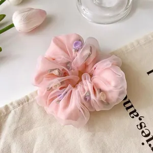Detail of pink organza scrunchie with handmade purple and white mini floral accents
