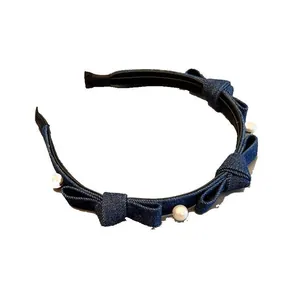 Denim headband featuring elegant white pearls and three delicate bows on dark blue fabric