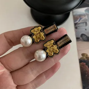 Detail of Korean style bear hair clips with faux pearls and golden embossed textures