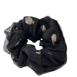 Elegant black organza scrunchie with white 3D floral accents for stylish hair styling