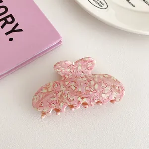 Detail showing marble texture acetic acid hair claw clip in pink and cream finish