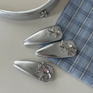 Silver bow hairband and heart crystal hair clips on blue plaid background