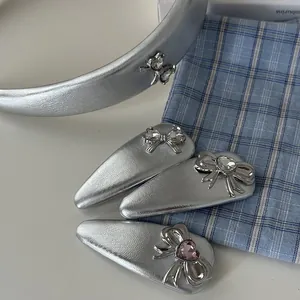 Silver bow headband and hair clip set with heart gemstones on a blue plaid background