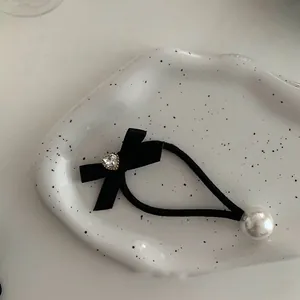 Chouchou élégant en velours noir avec nœud papillon, strass cœur et perle blanche