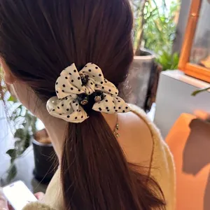 Élastique à cheveux chic avec nœud à pois et perles porté par un mannequin