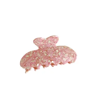 Pink and white marble texture acetate hair claw clip for women on white background