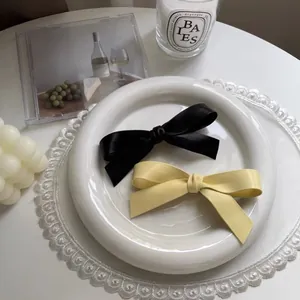 Barrettes à cheveux élégantes en cuir noir et beige sur un support en dentelle chic