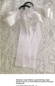 Detail of white satin ribbon bow with high-elastic hair tie on lace background