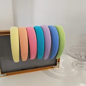 Macro detail of wide padded headbands in seven macaron colors on a gold frame