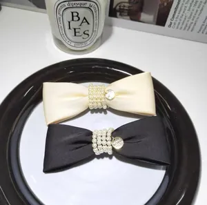 Elegant velvet bow hair clips set with pearls and gold pendants in black and cream white