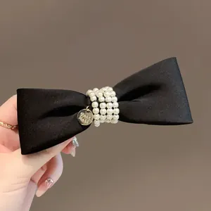 Elegant black satin velvet bow hair clip featuring pearl center and gold handmade tag