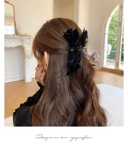 Pince à cheveux élégante en plumes noires sur une femme pour un style chic