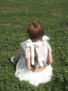 Detail of large white satin bows on the back of a sweet pastoral style white dress