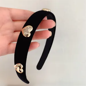 Elegant black velvet headband featuring textured gold metal heart accents for daily wear