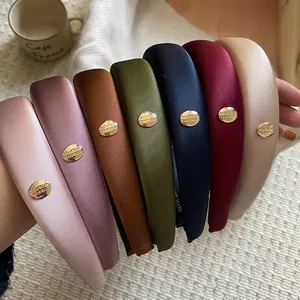 Elegant satin padded headbands with gold metallic oval label and believe engraving