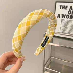 Detail of hand made yellow and white plaid fabric headband with artisan label