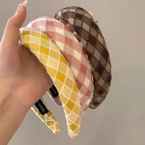 Detail of plaid fabric headbands with thick sponge padding in yellow, pink and brown
