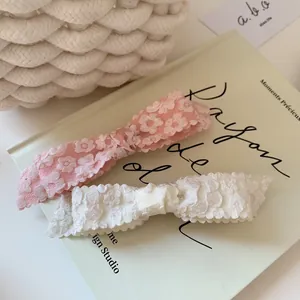 Pink and white lace floral bow hair clips set on vintage book for French style