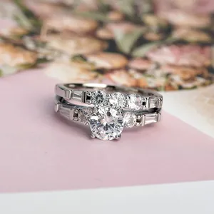 Set di anelli di fidanzamento in argento con zircone su sfondo floreale rosa elegante