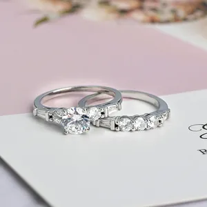 Elegante set di fedi nuziali in argento con zircone rotondo e fasce con accenti pavé