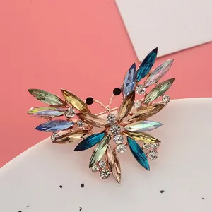 Gedetailleerd overzicht van vlinderbroche met kleurrijke kristallen en roségoud