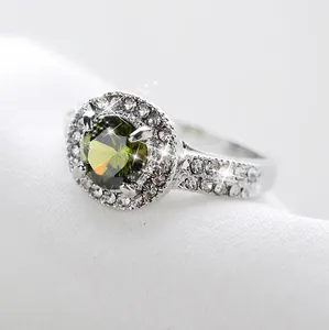 Anillo elegante de plata con gran gema verde y halo de cristales blancos brillantes