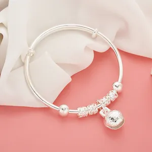 Detailed macro view of adjustable silver baby bangle with carved flower bells