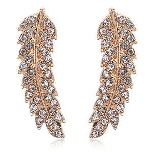 Close-up of rose gold leaf earrings with sparkling rhinestone crystals on white background